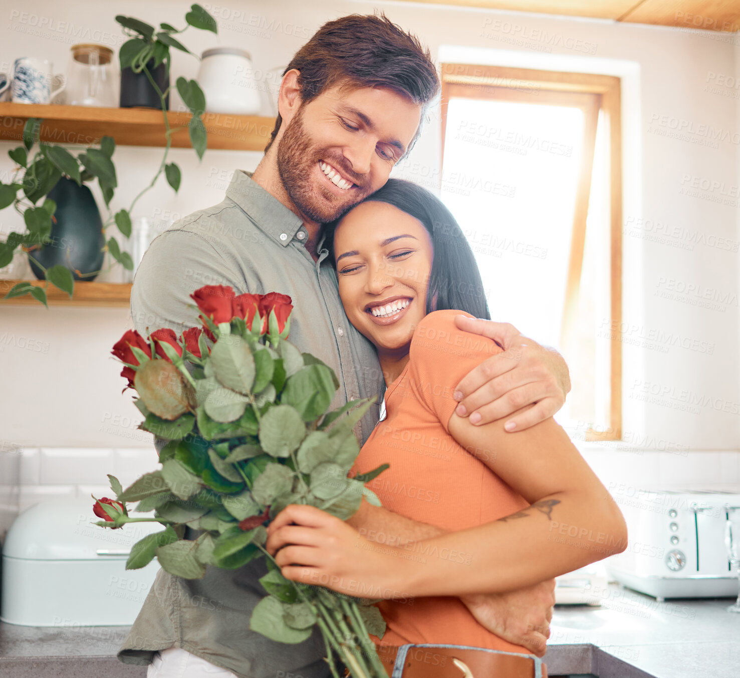 Buy stock photo Happy, couple and hug in home with flowers, bonding together or romantic connection for anniversary. People, dating and love in house with embrace, interracial relationship or roses bouquet for gift.