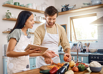 Buy stock photo Tablet, cooking or interracial couple in kitchen with vegetable, online recipe or nutrition blog. Smile, tech or people at home for meal prep, food guide or cut organic carrots to help for vegan diet