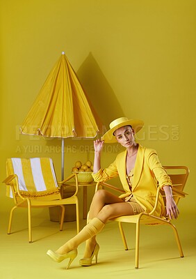 Buy stock photo Portrait, fashion or woman with chair in studio, amber makeup or summer outfit for tropical aesthetic. Trendy color, bold eyeshadow or person with chic wardrobe, vacation style or yellow background