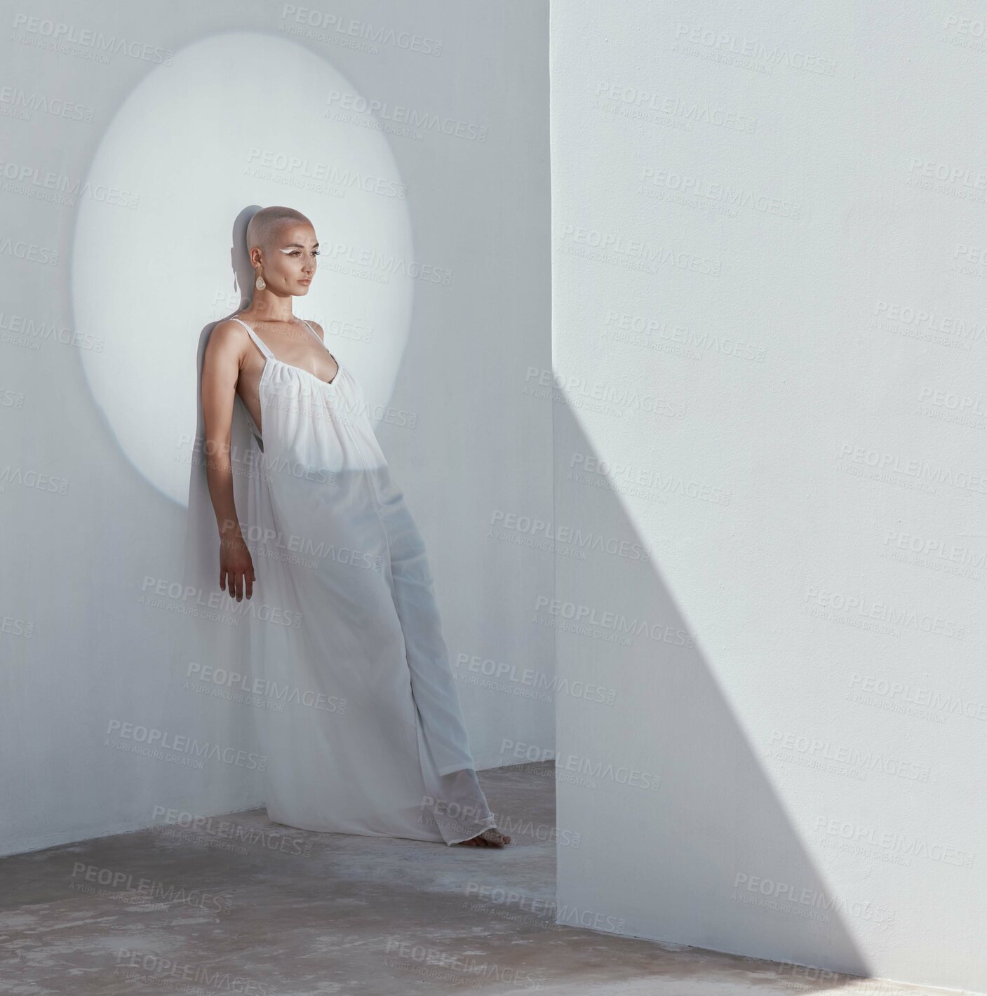 Buy stock photo Woman, fashion and makeup on wall with spotlight, thinking and chiffon white dress for trendy outfit. Artistic, person and creative vision with beauty cosmetics, blond hair or serious for edgy style.