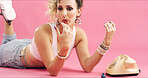 Retro, telephone and woman with nail polish in studio for phone call, relax and 80s outfit. Drying, blowing and person with landline with vintage fashion, manicure and pampering by pink background.