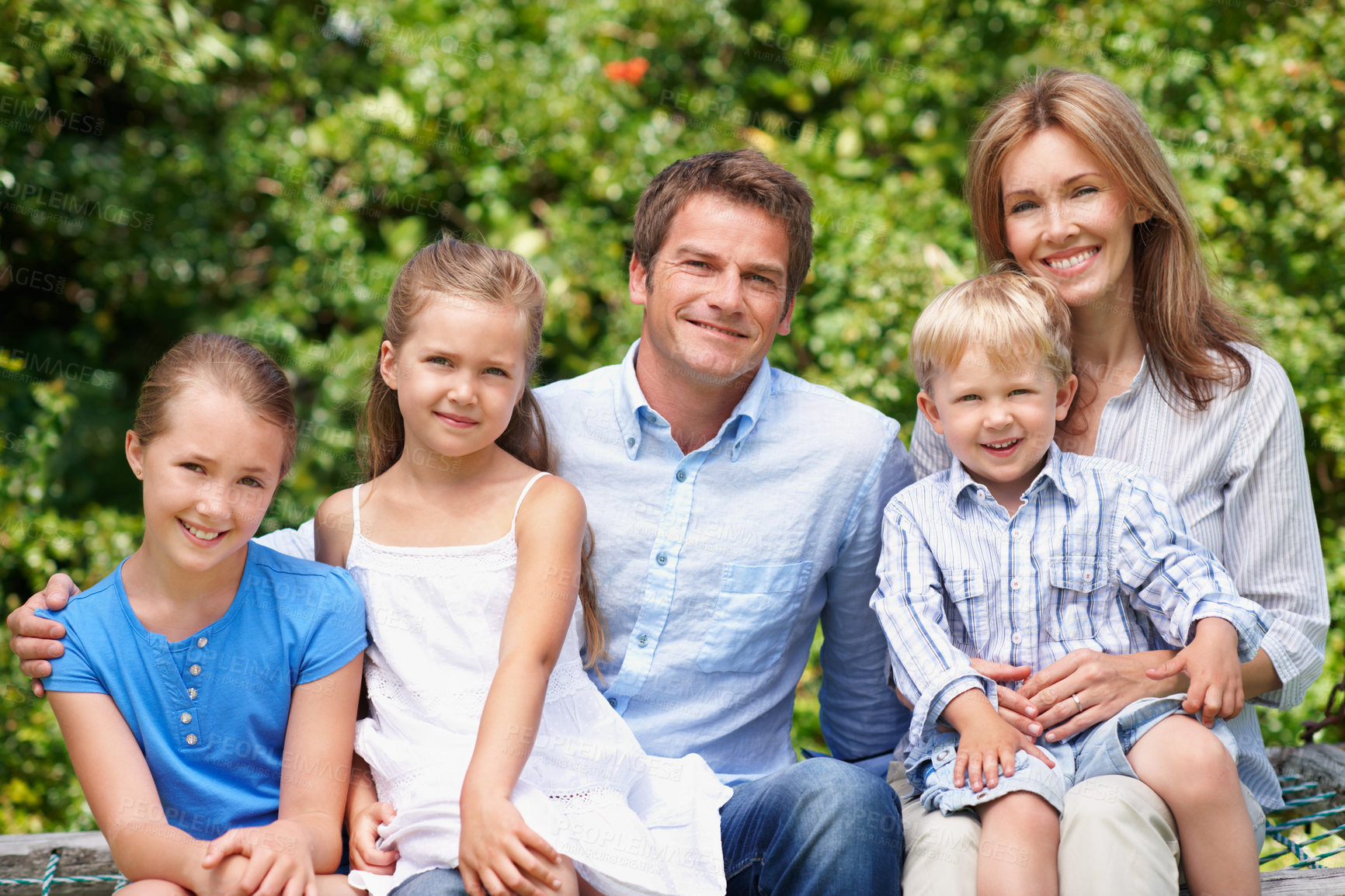 Buy stock photo Portrait, parents and smile with kids at park for love, affection and bonding together on holiday. Happy, people or embrace children for support, family connection and vacation getaway in countryside