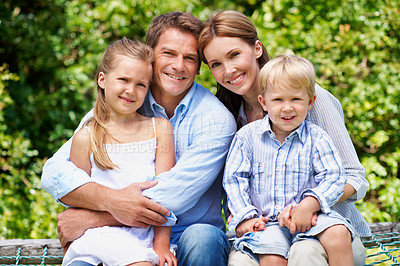 Buy stock photo Smile, parents and relax with kids at park for love, affection and bonding on holiday trip. Portrait, people and bench with children for support, family connection and vacation getaway in countryside