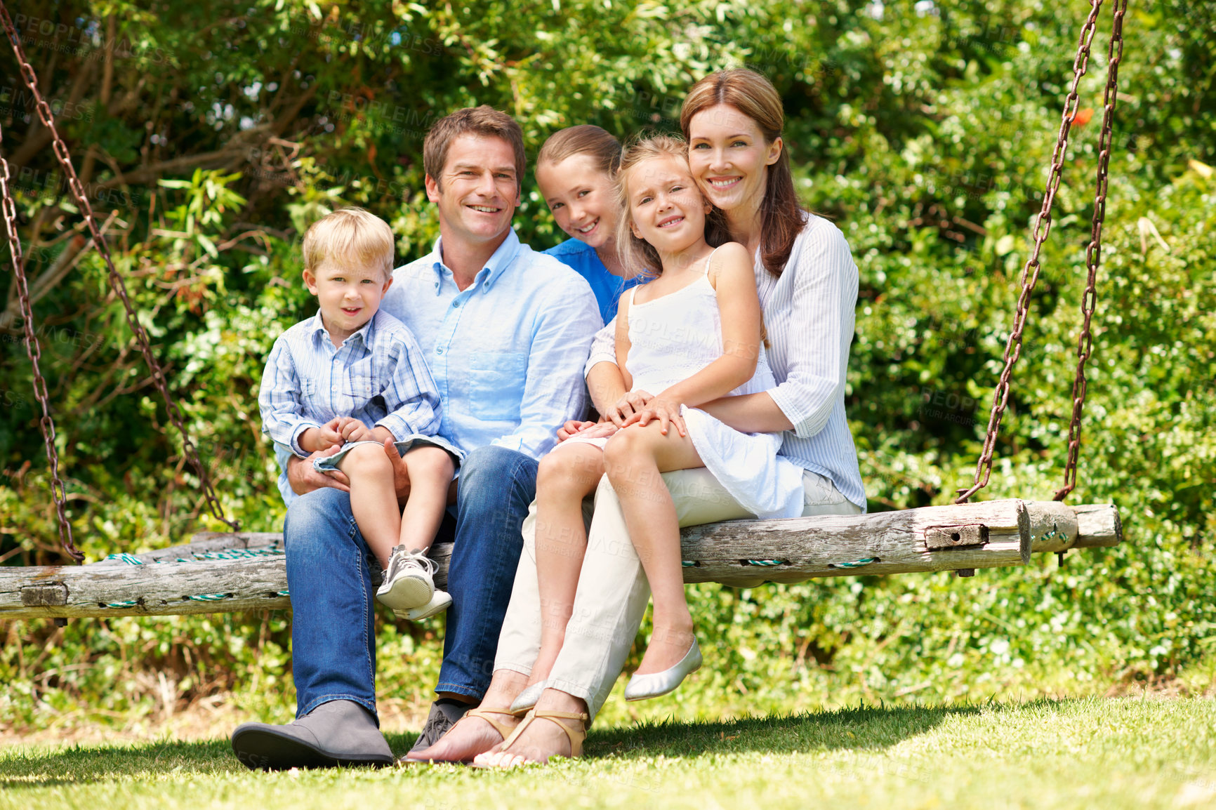 Buy stock photo Backyard, smile and summer with family on swing together for bonding, love or support. Portrait, relax or security with mom, dad and sibling children outdoor in garden for break, connection or growth