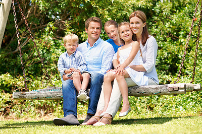 Buy stock photo Backyard, portrait and summer with family on swing together for bonding, love or support. Relax, security and smile of mom, dad and sibling children outdoor in garden for break, connection or growth