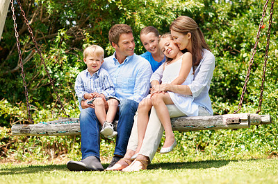 Buy stock photo Relax, smile and summer with family on swing together for bonding, love or support. Backyard, portrait or security with mom, dad and sibling children outdoor in garden for break, connection or growth