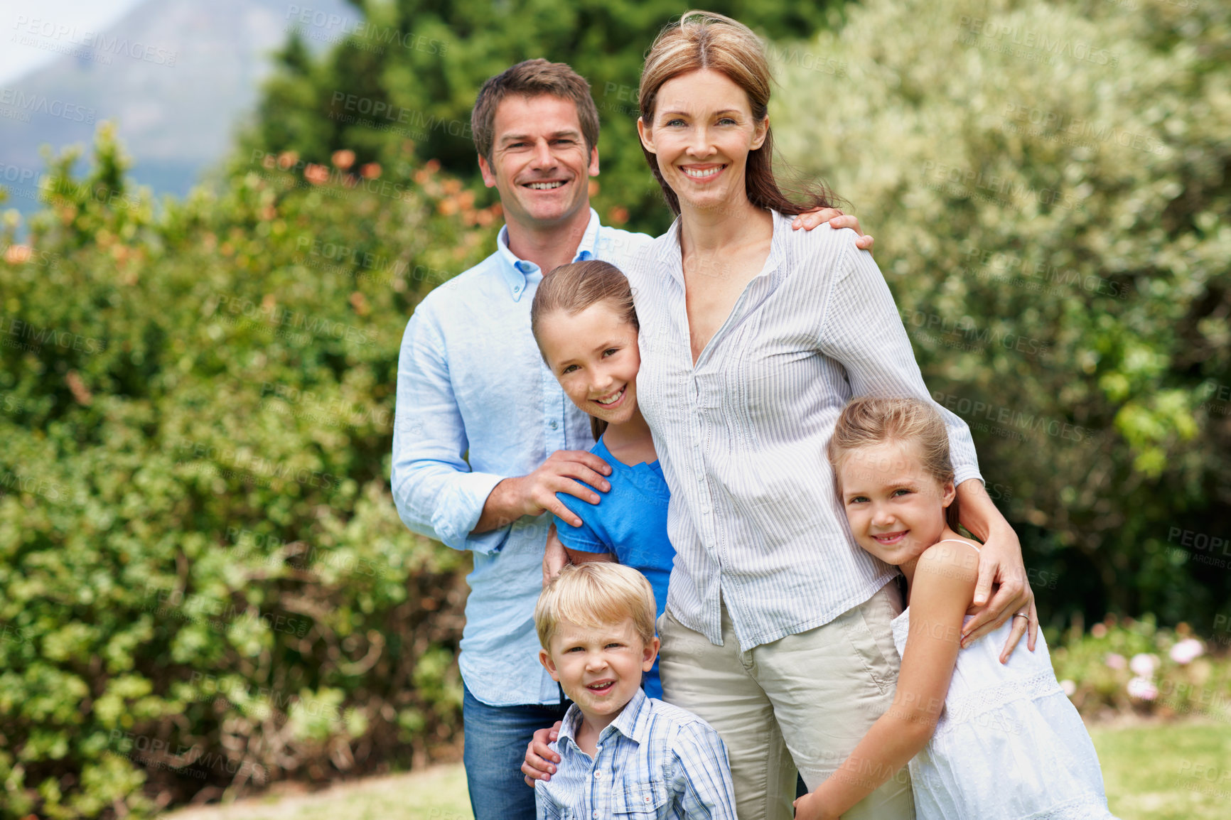 Buy stock photo Portrait, parents and smile with children outdoor for love, parent support and bonding together. Happy, people and affection with kids, family connection and weekend break on vacation trip in nature