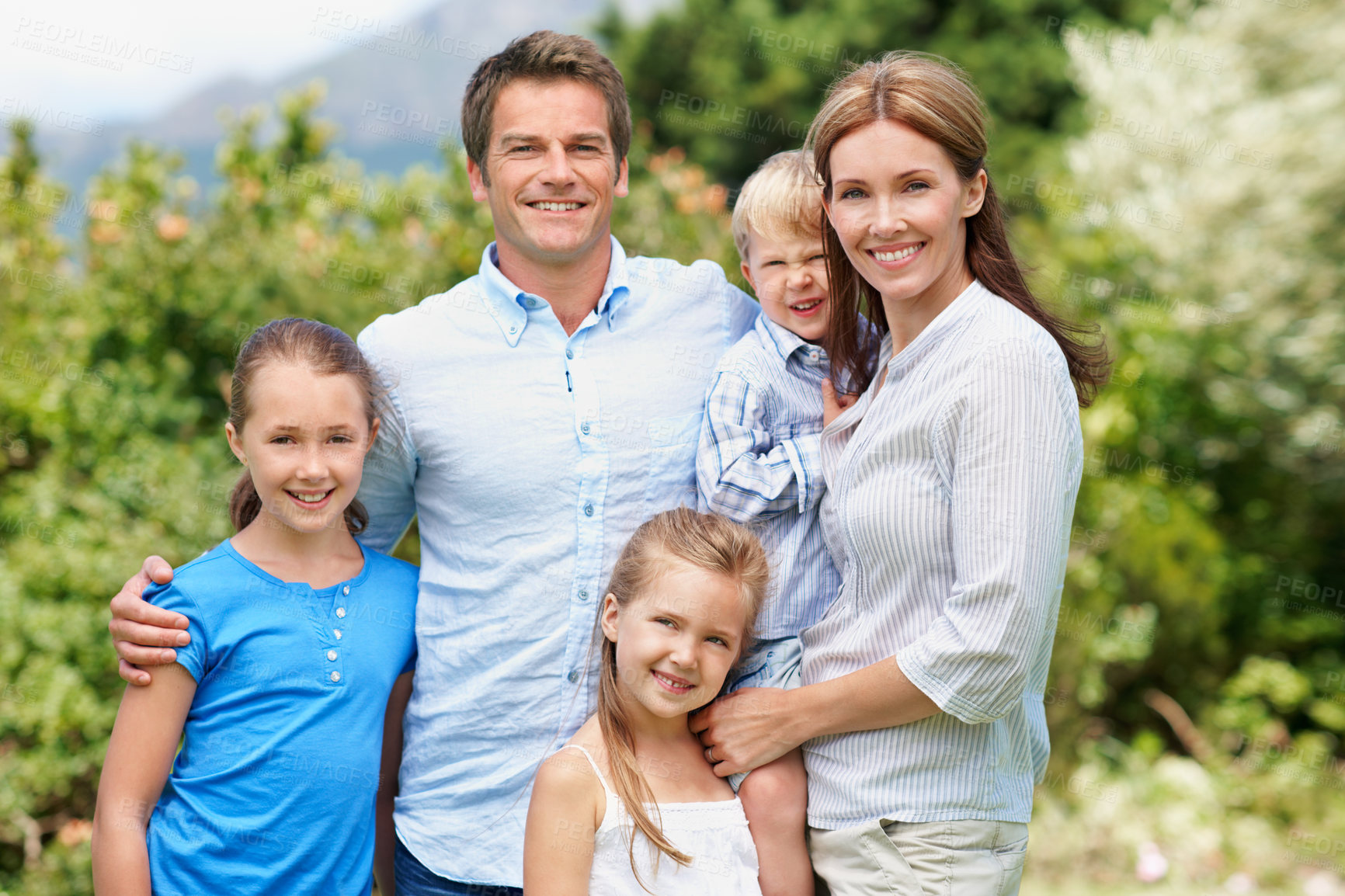 Buy stock photo Portrait, parents and happy with children outdoor for love, parent support and bonding together. Smile, people and affection with kids, family connection and weekend break on vacation trip in nature