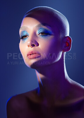 Buy stock photo Woman, beauty or eyeshadow in studio with glitter, iridescent sparkle or reflection for edgy aesthetic. Creative, person and makeup cosmetics with shadow, glowing skin and piercing on blue background