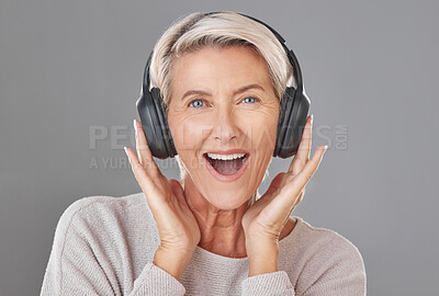 Buy stock photo Portrait, headphones and mature woman in studio with smile for sound, music or listening experience. Happiness, excited and person with wow for audio quality, podcast or news on gray background