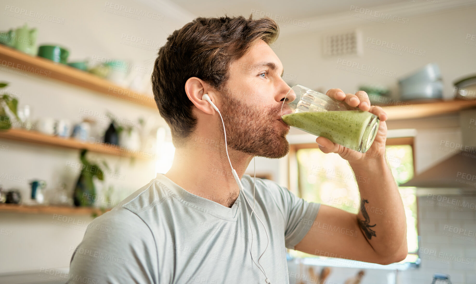 Buy stock photo Wellness, earphones and man in home with smoothie, organic juice and protein shake for gut health. Diet, person and audio tech in kitchen with green drink, supplement and nutritional tips in podcast