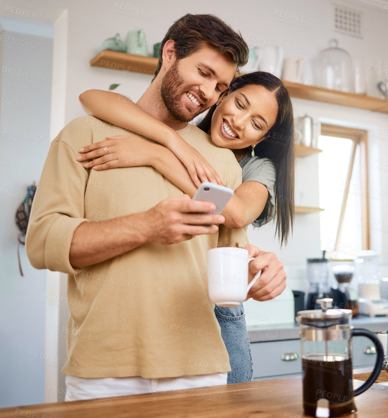 Buy stock photo Couple, hug and phone in kitchen with coffee, date reservation and anniversary reminder in calendar. Happy woman, man and mobile in home for social media memory, browsing app and love with drink