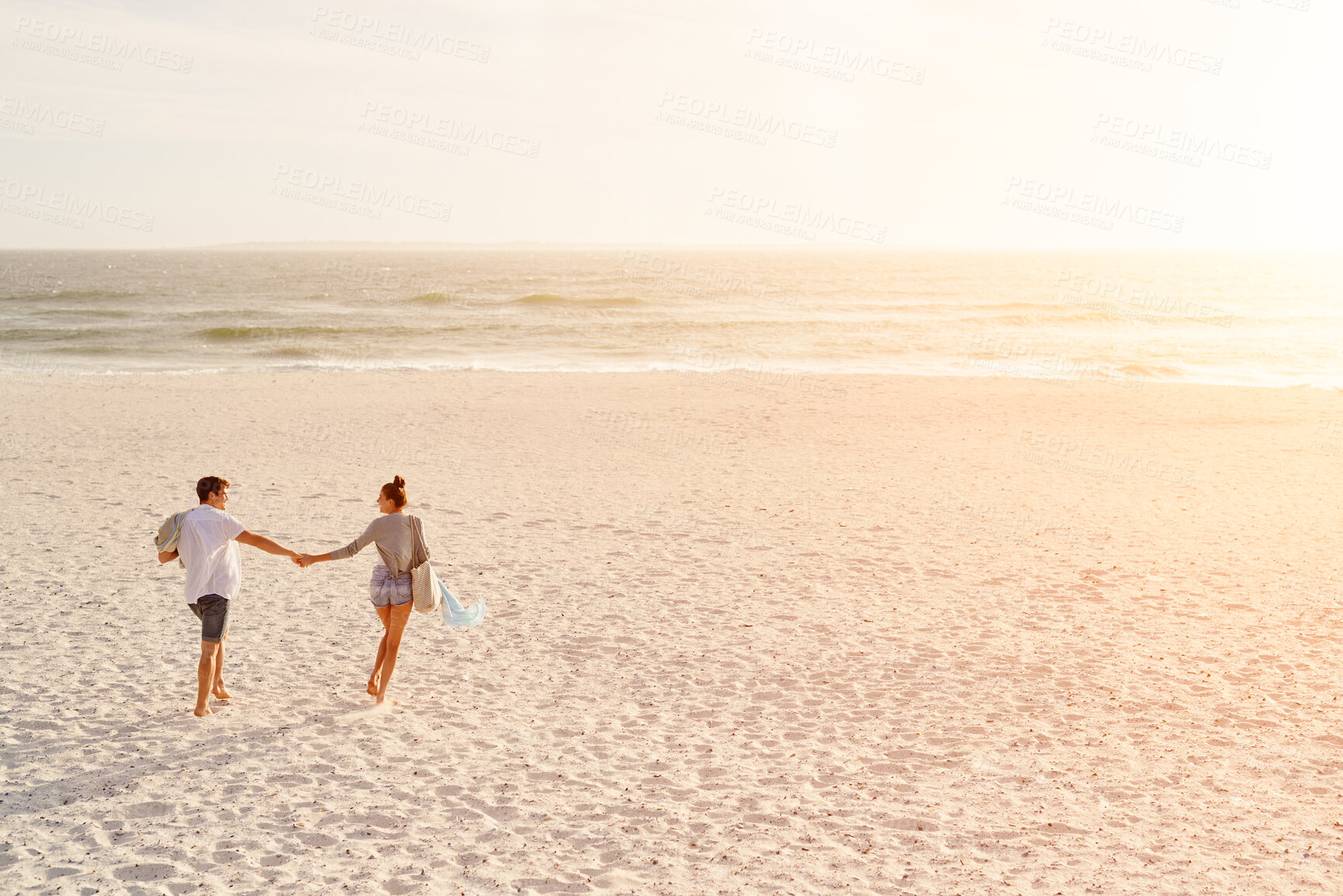 Buy stock photo Love, couple and holding hands at beach, sunset or travel on summer vacation for romance with partner. Man, woman and connection by ocean with happiness, back and walk with space on holiday together