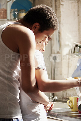 Buy stock photo Couple, hug and smile with tea in kitchen, together and morning routine with partner or relationship. Coffee, preparation and start day with spouse, embrace and happy people with connection in house