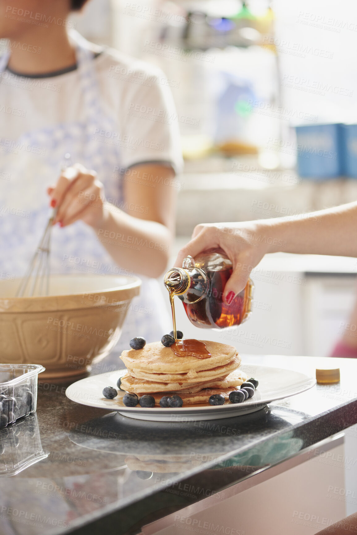 Buy stock photo Pancakes, hands and family with breakfast in home for bonding, eating and cooking together. Maple syrup, blueberries and people in morning for baking with sweet treat in kitchen at apartment.