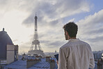 Travel man using digital tablet technology view Eiffel Tower Paris hotel terrace destination vacation