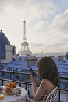 Travel woman view Eiffel Tower Paris smart phone technology social media hotel terrace breakfast destination vacation