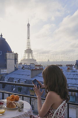 Buy stock photo Breakfast, Eiffel Tower and phone with woman on balcony of hotel for holiday, travel or vacation. App, coffee and food with tourist person on terrace of accommodation for sightseeing in Paris