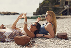 Tourist girls relax on beach using smart phone to connect on video waving on adventure travel