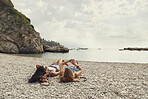 Travelling girls relaxing on beach use smart watch technology on adventure travel trip to connect