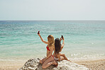 Beautiful girl friends taking selfies with smart phone technology on paradise beach destination summer wanderlust vacation