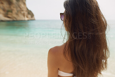 Buy stock photo Woman, beach and travel with sunglasses for holiday, outdoor vacation or adventure in nature. Back view, female person or traveler with natural scenery on ocean coast for weekend getaway on island