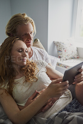 Buy stock photo Tablet, relax and couple on bed in apartment for watching movie, series or show on app together. Happy, bonding and man with woman on technology for streaming film in bedroom at home on weekend.