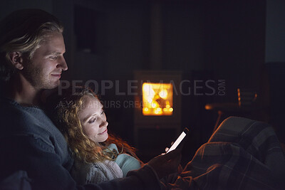 Buy stock photo Couple, smile and relax with phone at night, comfortable or watching movie on weekend, love and cozy. Happy people, online and streaming film with mobile, bonding and entertainment on website in home