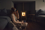 Woman wearing vr headset 3D augmented reality at home cosy fire watching entertainment concept