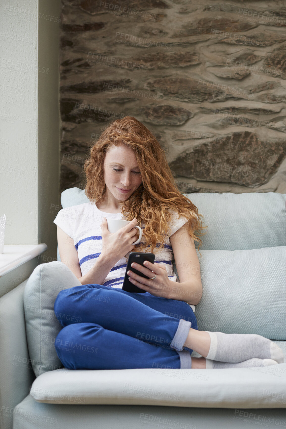 Buy stock photo Phone, message and woman with coffee in lounge, online or communication with contact on social media. Relax, home and happy person with mobile for chat, reading and chilling with beverage in house