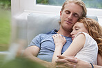 Beautiful couple cuddle on sofa in love at home in happy affectionate relationship