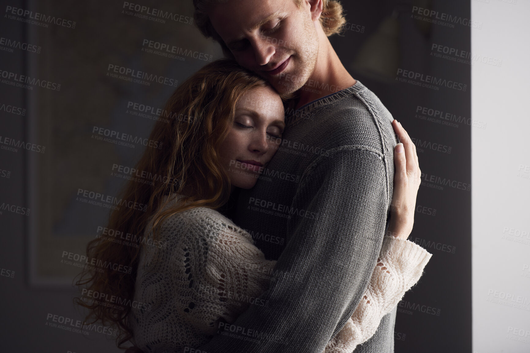 Buy stock photo Hug, love and security with couple in home together for emotional support or relationship trust. Calm, happy or safety with man and woman embracing in apartment for bonding or wellness at night