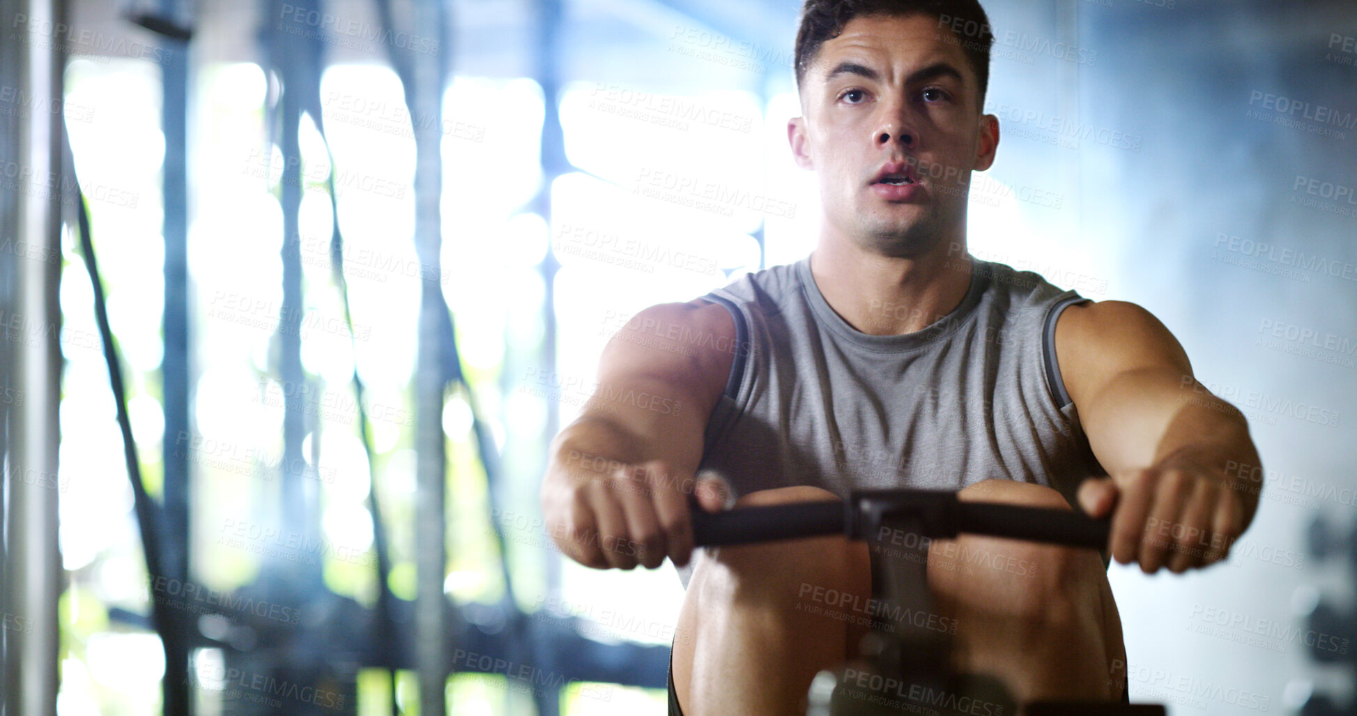 Buy stock photo Fitness, workout or man in center with rowing, power or strength exercise for body improvement. Serious, core endurance or athlete with machine, intense training or challenge for muscle development.