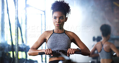 Buy stock photo Fitness, training or woman in gym with rowing, cardio or strength exercise for body improvement. Serious, endurance or African person with machine, core workout or challenge for muscle development.