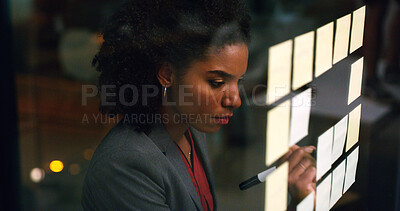 Buy stock photo Night, businesswoman and writing at glass wall with sticky note, brainstorming and planning for audit. Late, black person and accountant in office with strategy, problem solving and risk assessment.