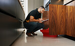 Checklist, plumber and man with tablet in kitchen for pipeline maintenance or valve corrosion. Digital tech, inspection or handyman with leak report in home for filter system installation or repair