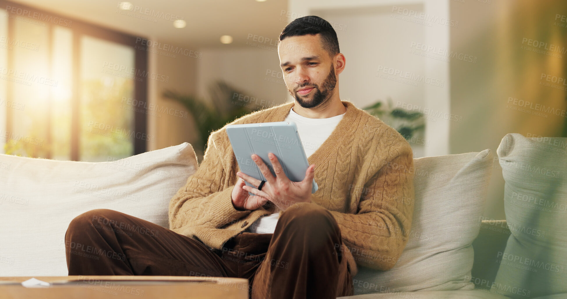 Buy stock photo Tablet, relax and man in apartment to watch show, online search and video entertainment on sofa. Tech, chill and person at home for streaming movie, subscription service or download film on internet