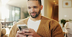 Mobile, relax and man in home for text message, online dating and social media notification on sofa. Smile, phone and person at living room for communication, matching and check profile on internet
