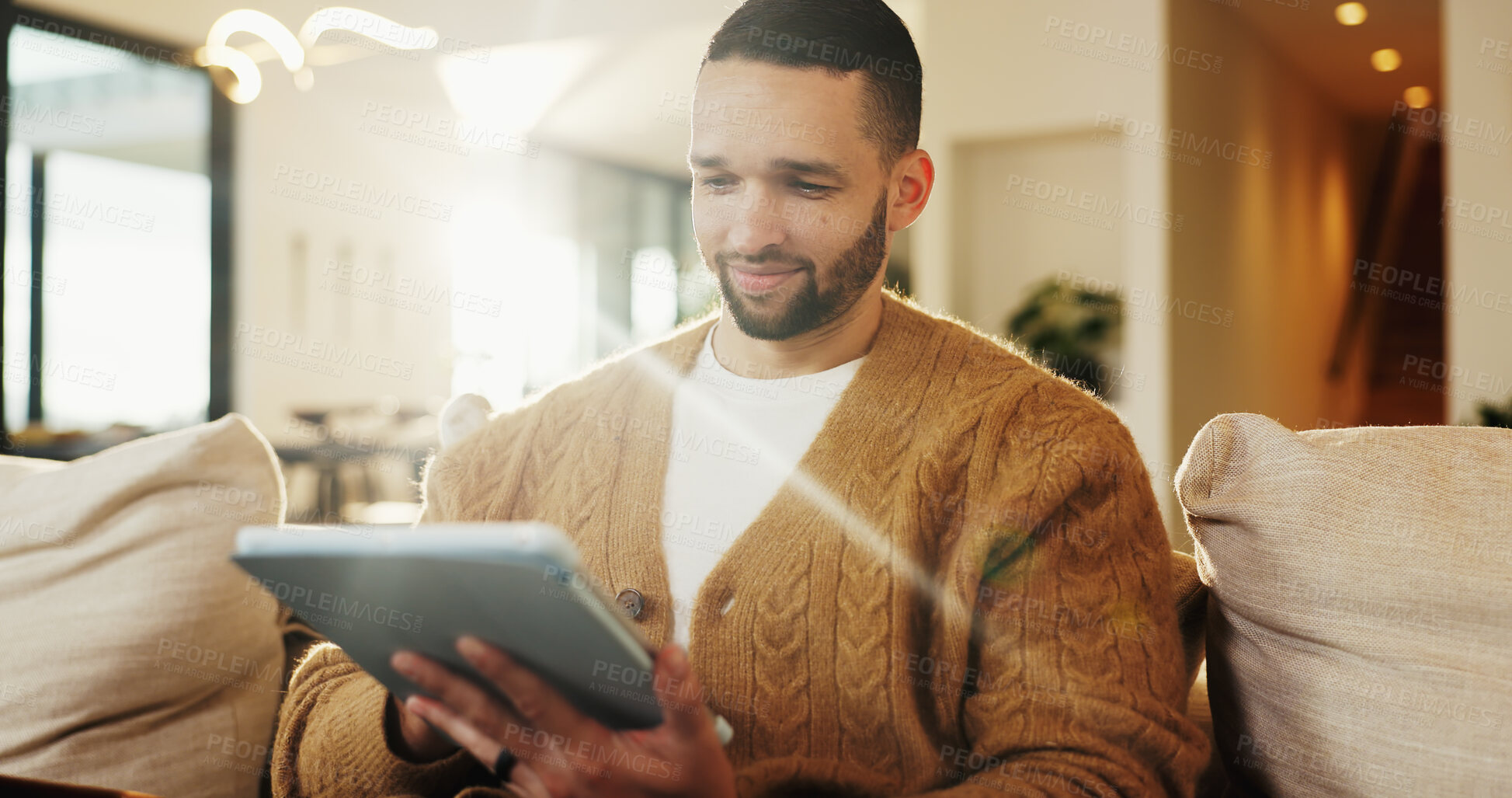 Buy stock photo Tablet, relax and man in home for reading ebook, online search and entertainment on sofa. Tech, smile and person at living room for social media profile, browsing internet or news with information