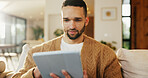 Tablet, relax and man in apartment for reading ebook, online search and entertainment on sofa. Tech, smile and person at home for social media profile, browsing internet or news with daily update