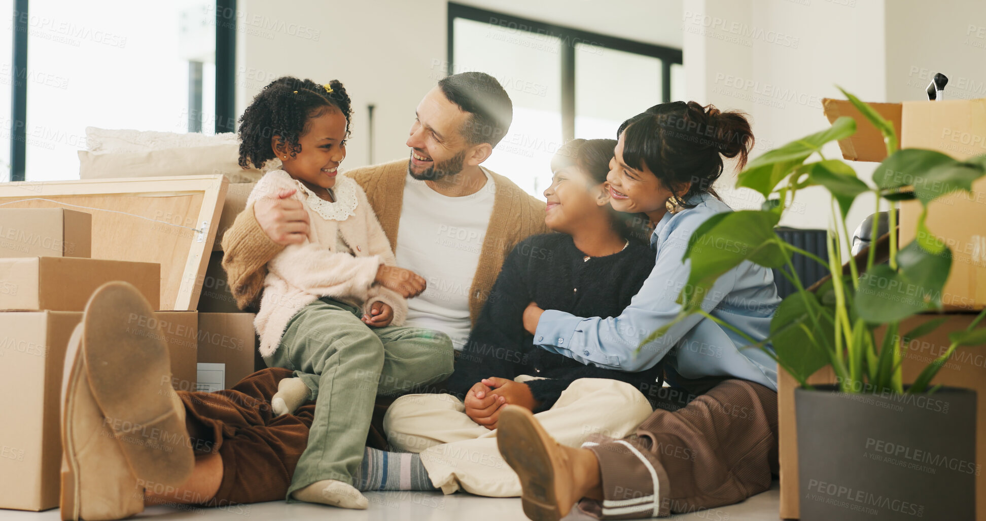 Buy stock photo Real estate, parents or kids in living room with boxes, fresh start or happiness at dream house. Relocation, smile or people in home with embrace, family property or mortgage for new homeowners.