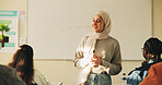 Education, muslim woman and teacher in classroom at high school with tips for study, learning or test. Curriculum, islamic person and female educator with students for teaching or academic support.