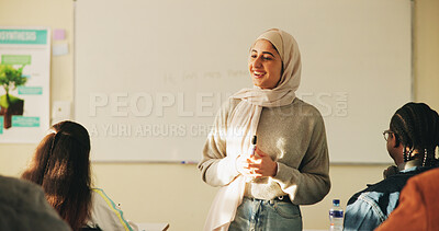 Buy stock photo Education, muslim woman and teacher in classroom at high school with study tips, learning or smile. Curriculum,  person and female educator with students for teaching or academic support in lesson