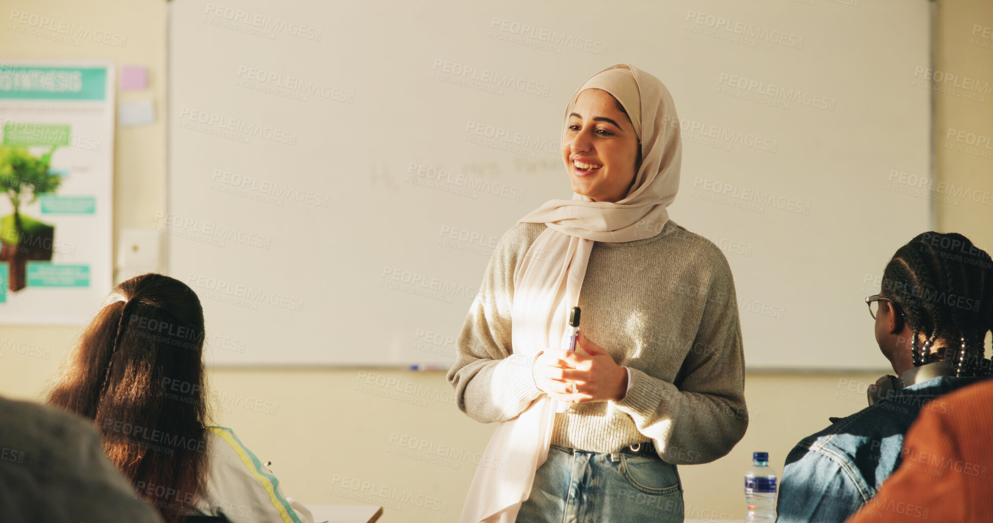 Buy stock photo Education, muslim woman and teacher in classroom at high school with study tips, learning or smile. Curriculum,  person and female educator with students for teaching or academic support in lesson