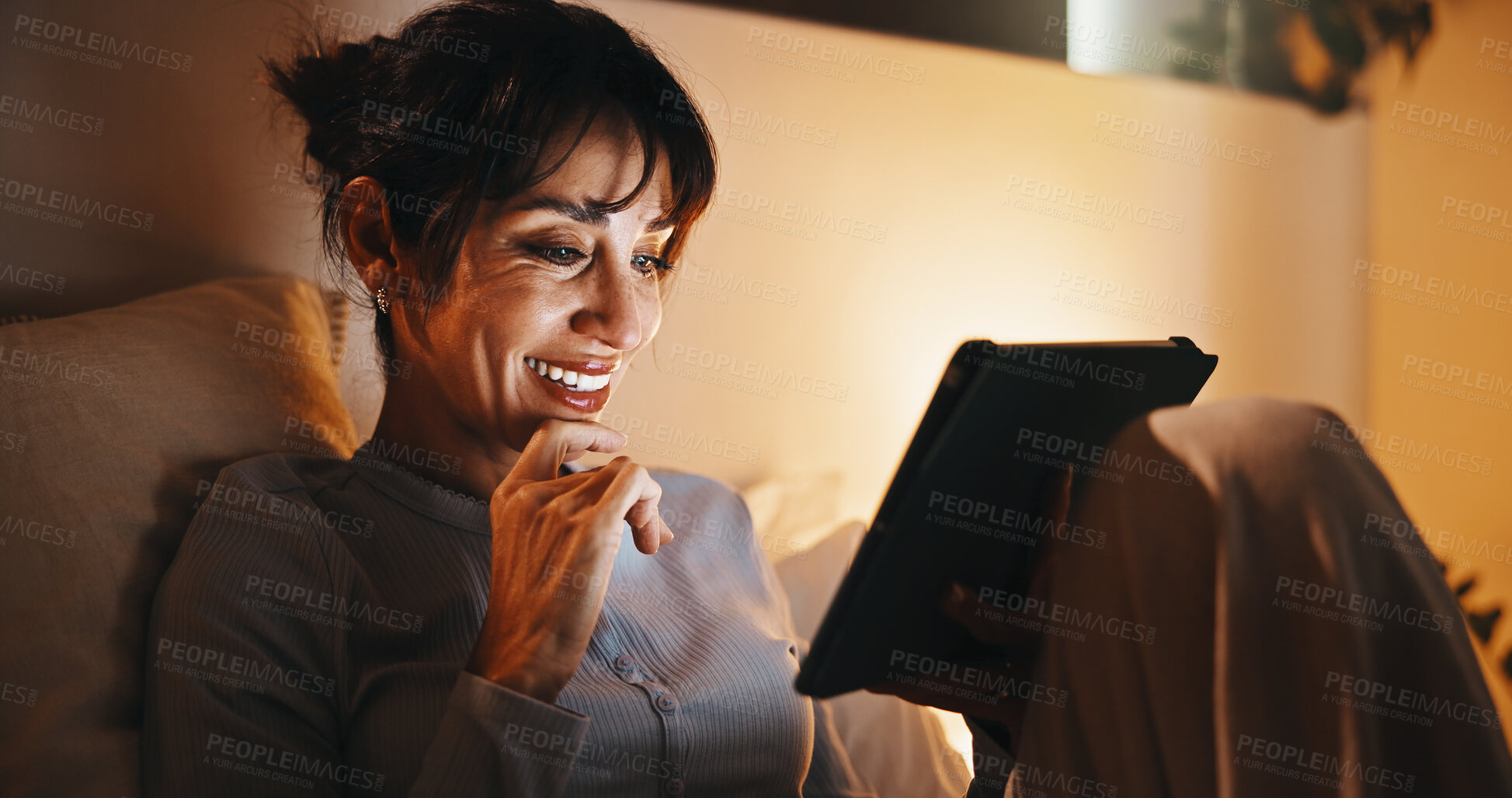 Buy stock photo Laughing, woman and relax with tablet in bedroom, entertainment and streaming funny movie on website. Happy, mature person and watch comedy series with subscription at night, online or humour in home