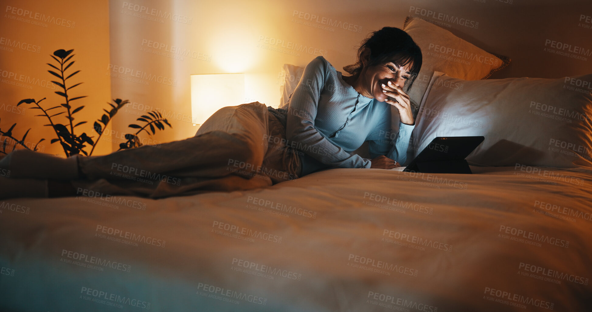 Buy stock photo Bed, woman and relax with tablet at night for comedy podcast, funny series or unwind on weekend. Cozy, mature person or laugh with tech in home for comic film, tv show subscription and entertainment