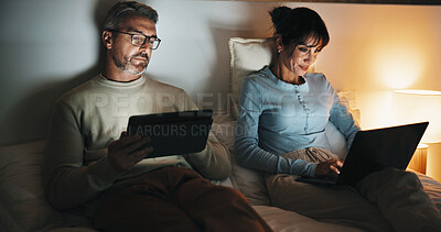 Buy stock photo Couple, relax and tech in bedroom at night for distraction, emotional distance and browsing website. Mature people, rest and digital with internet addiction, silent interaction and overtime at house