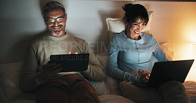 Buy stock photo Bed, couple and relax with tech at night for streaming service, bonding and funny tv show. Laptop, mature people or laugh with tablet in home for comedy movie, weekend entertainment and relationship