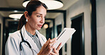 Hospital, tablet and doctor with digital records, schedule or healthcare app for research. Clinic, tech and physician woman with telehealth report, review or reading of online results in hallway