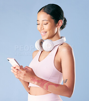 Buy stock photo Phone, smile and woman in studio for fitness, membership application or online app. Schedule, gym and female person with tech for networking, wellness contact and social media on blue background